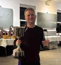 Pool coach Andy Bannan holding a silver singles trophy after a tournament win